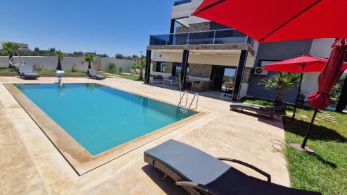 ein Swimmingpool im Hinterhof eines Hauses in der Unterkunft Villa confort in Oulad Tayeb