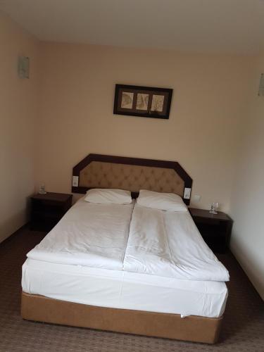 a bedroom with a bed with a white bedspread at Hotel Podkovata in Etropole