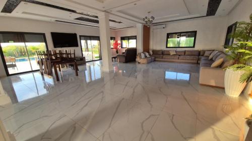 ein Wohnzimmer mit einem großen weißen Marmorboden in der Unterkunft Villa confort in Oulad Tayeb