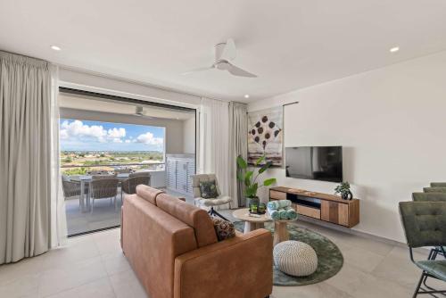 a living room with a couch and a television at Coral Whisper - Aquamarine 8 in Willemstad