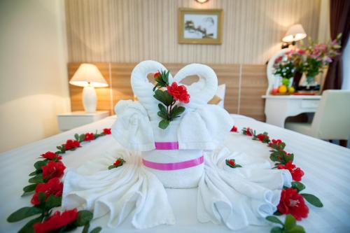 a towel sculpture of two swans on a bed at Palm Beach Hotel in Nha Trang