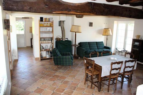 sala de estar con mesa y sillas en Gîte La Poterie, en Jupilles