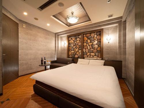 a bedroom with a large white bed and a couch at ホテルレジェンドプラス-Adult only in Kyoto