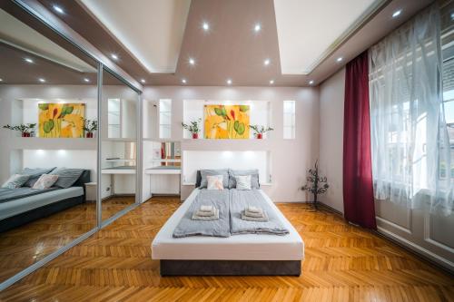 ein Schlafzimmer mit zwei Betten und einem großen Fenster in der Unterkunft Széchenyi Apartman (IV Deluxe) Miskolc belvárosában in Miskolc