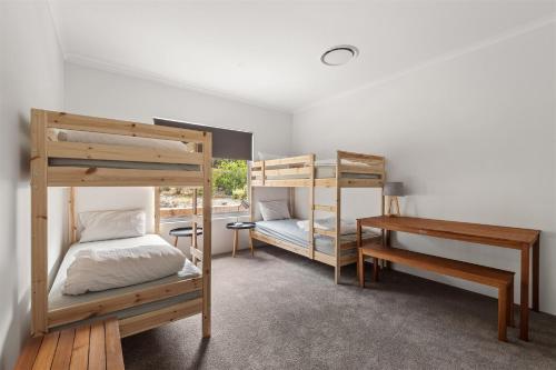 una stanza con due letti a castello e una scrivania di Bush to Bay - Pet-Friendly Retreat Near Injidup a Yallingup