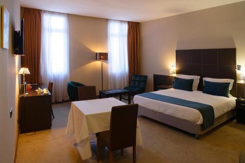 a hotel room with a bed and a table and chairs at TANA-Boutique Hôtel in Antananarivo