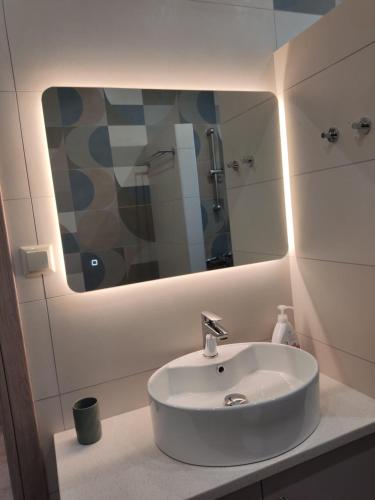 een badkamer met een witte wastafel en een spiegel bij Rias Efthimiou House in Kanallákion