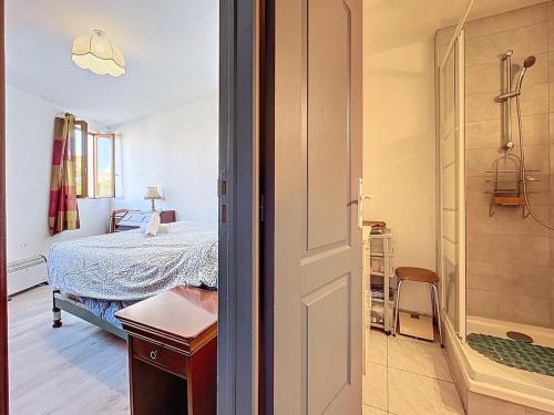 a bedroom with a bed and a bathroom with a shower at Le poli - 6 pers - Centre - vue sur la cathédrale in Narbonne