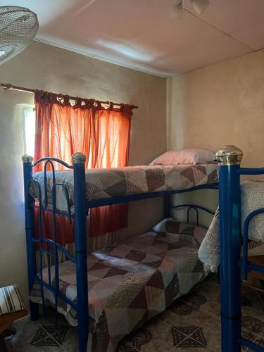 a bedroom with two bunk beds and a window at Quinta Atardeceres in Aldea Brasilera