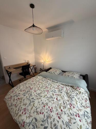 una camera con letto, scrivania e lampada di Maison à la campagne a Quarouble