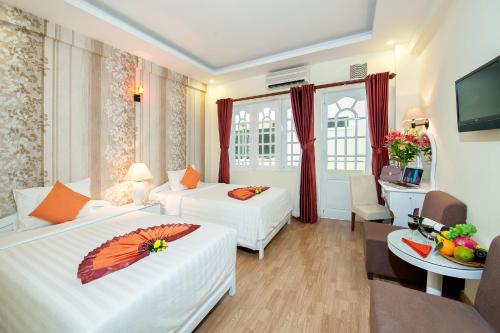 a hotel room with two beds with an umbrella on it at Palm Beach Hotel in Nha Trang