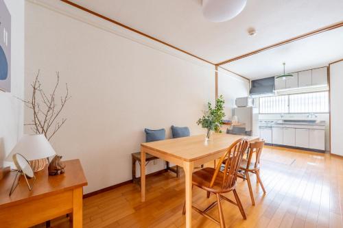 a kitchen and dining room with a wooden table and chairs at GUEST HOUSE Hotori 2nd in Otsu
