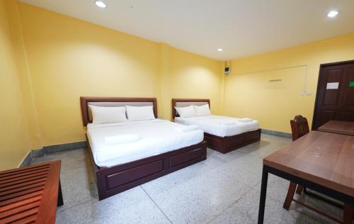 um quarto com duas camas, uma mesa e uma escrivaninha em Excel Hotel Bangkok former Sri Krungthep Hotel em Banguecoque