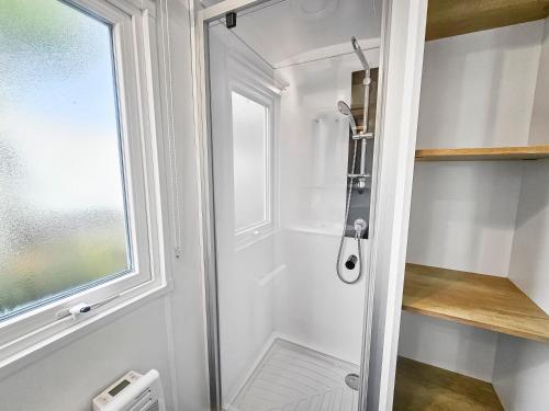 a shower with a glass door in a bathroom at L'horizon du bonheur in Litteau