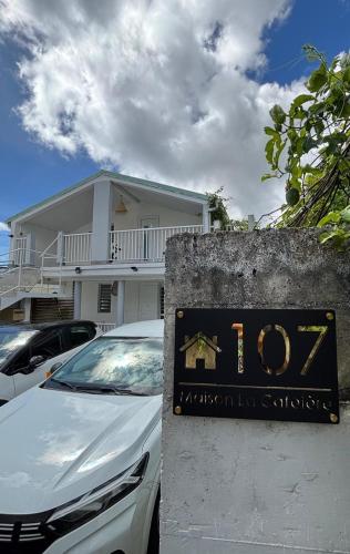 un cartel delante de una casa con un coche en Maison La Caféière, en Saint-Claude