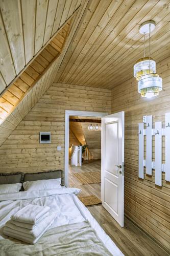 a bedroom with a bed and a wooden ceiling at Poienărei Forest Heaven in Poenărie