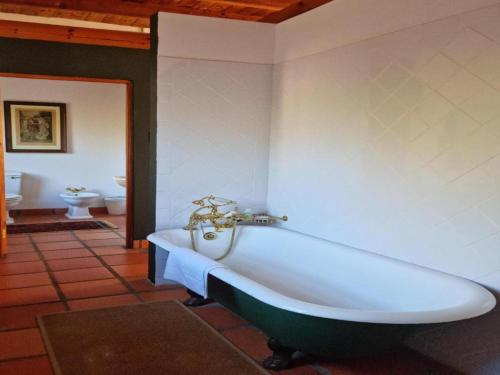 a bath tub in a room with a bathroom at Red Ridge Mountain Lodge in Buffelskloof
