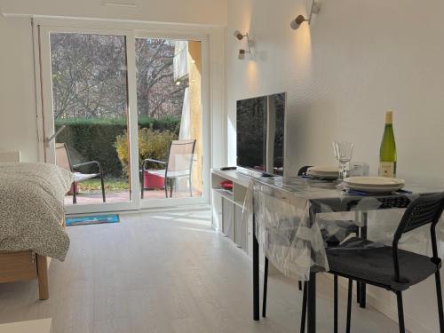 ein Wohnzimmer mit einem Esstisch und einem TV in der Unterkunft Le Nid des Frênes - Studio au Cœur de la Nature in Boersch