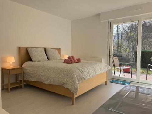 ein Schlafzimmer mit einem Bett, auf dem ein Teddybär liegt in der Unterkunft Le Nid des Frênes - Studio au Cœur de la Nature in Boersch