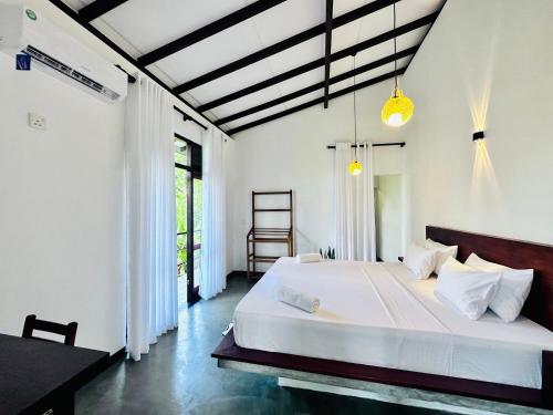 ein Schlafzimmer mit einem großen weißen Bett in einem Zimmer in der Unterkunft Surfside Paddy Villa in Babarenda Central