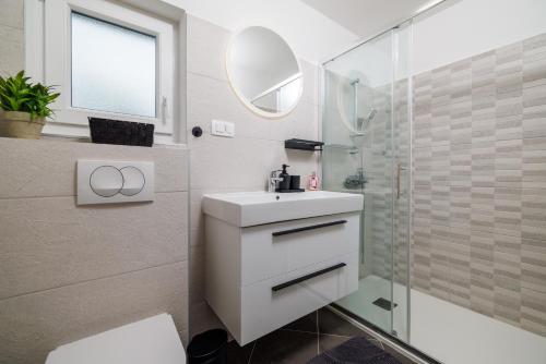 a bathroom with a white sink and a shower at Kuca za Odmor Ena in Jadranovo