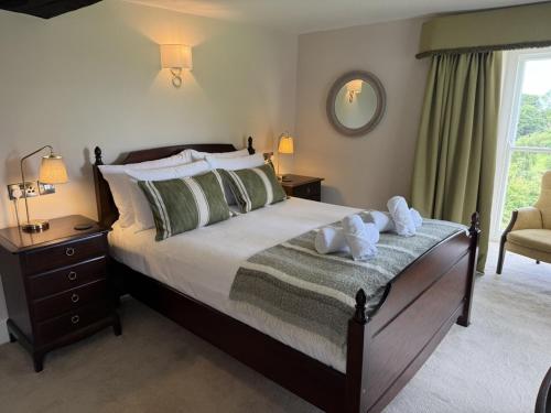 a bedroom with a bed with two towels on it at Maes Y Neuadd Country House in Talsarnau