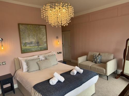 a bedroom with a large bed and a chandelier at Maes Y Neuadd Country House in Talsarnau
