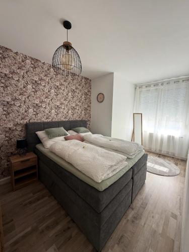 Ferienwohnung Rehn 1 في باد كيسينغن: غرفة نوم بها سرير كبير وثريا