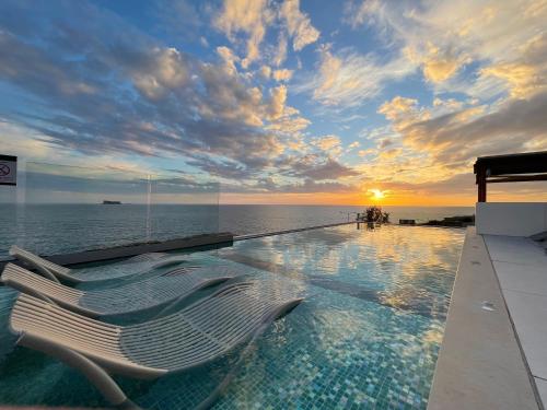 una piscina con una tumbona frente al océano en R Lapsi Guesthouse, en Siġġiewi
