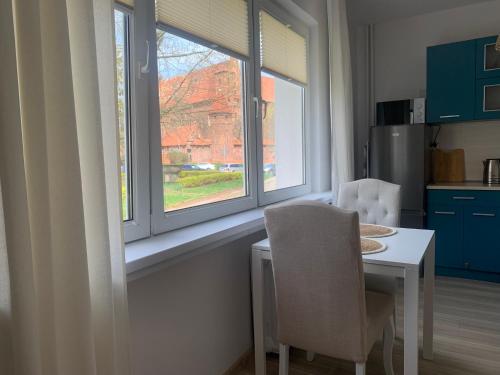 a kitchen with a table and two chairs and a window at Przy ZAMKU in Malbork