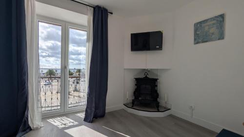 a living room with a fireplace and a large window at VistaClub in Setúbal