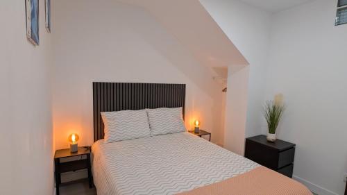 a bedroom with a bed and two night stands with lights at VistaClub in Setúbal