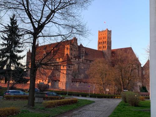 a large brick building with a tall tower at Przy ZAMKU in Malbork