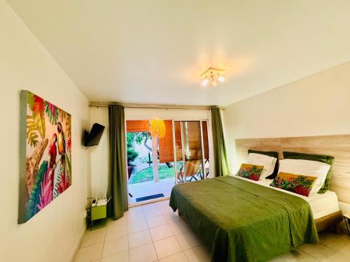 a bedroom with a green bed and a window at Superbe Studio Ultra COSY à 2 min de la PLAGE in Sainte-Anne
