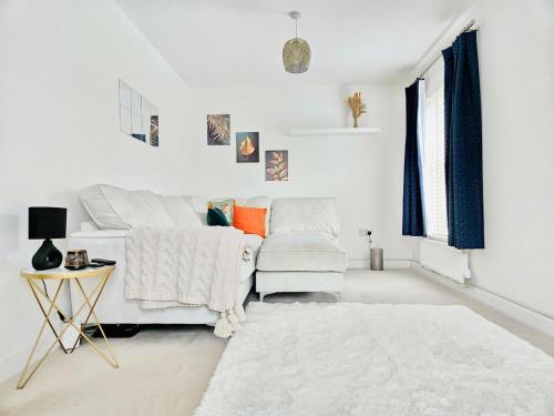 a white living room with a white couch and a table at Modern 3-Bed plus Office - Walk to Bicester Village in Bicester