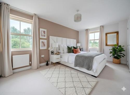 a bedroom with a white bed and a large window at Modern 3-Bed plus Office - Walk to Bicester Village in Bicester