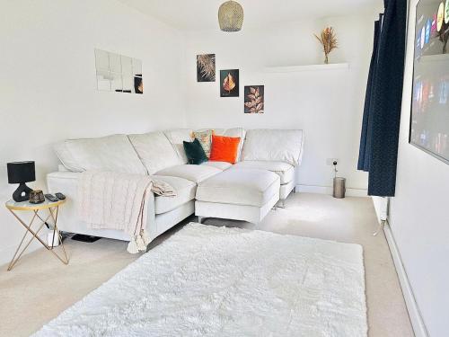 a white living room with a couch and a rug at Modern 3-Bed plus Office - Walk to Bicester Village in Bicester