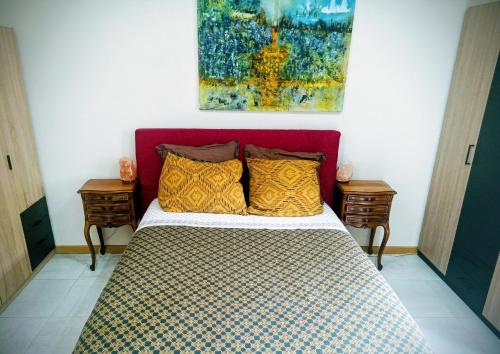 uma cama com uma cabeceira vermelha num quarto em Bel appartement à 10 minutes du marché de Noël de Strasbourg em Schiltigheim