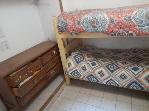 a bedroom with a bunk bed and a dresser at Hostel, La Casa del Patio in Bahía Blanca