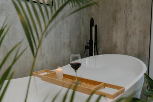 una candela e un bicchiere di vino accanto a una vasca da bagno di Landal Rockingham Forest a Wansford