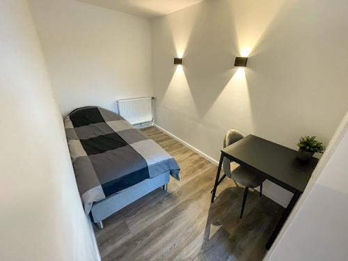 ein kleines Zimmer mit einem Bett und einem Schreibtisch in der Unterkunft 44 - 5 Modern appartement voor 6 personen in Weener