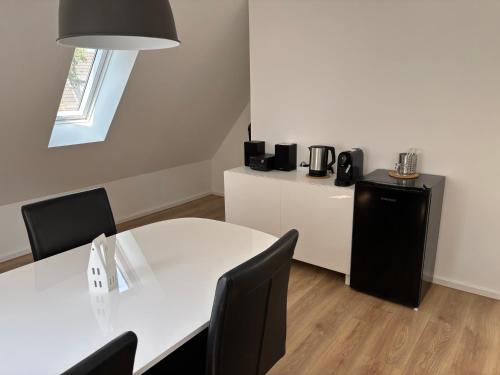 einen Tagungsraum mit einem weißen Tisch und Stühlen in der Unterkunft Ruhiges und citynahes Dachgeschoss-Nest in Düsseldorf