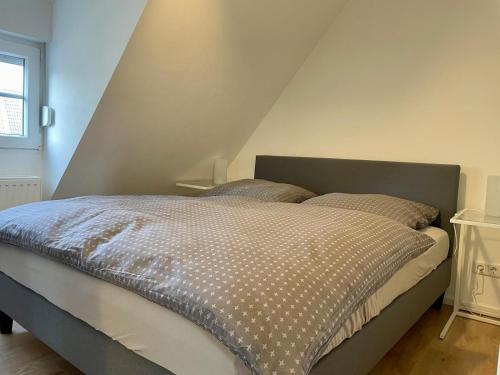 杜塞尔多夫Ruhiges und citynahes Dachgeschoss-Nest的一间卧室设有一张带尖顶天花板的大床