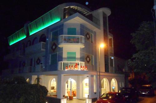 a building with green lights on top of it at night at Hotel Biancaneve Wellness in Marotta