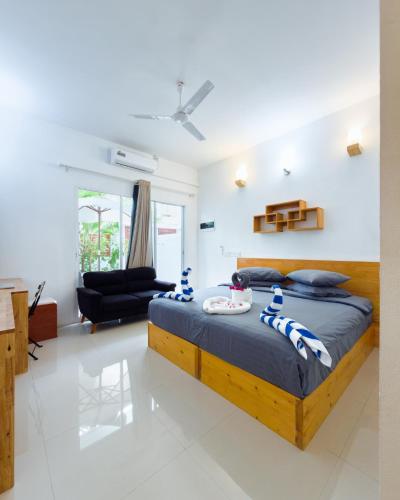 a bedroom with a bed and a living room at The Wave Dhigurah in Dhigurah