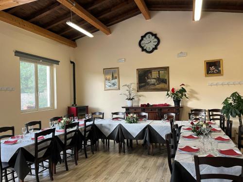 Una habitación con mesas y sillas y un reloj en la pared. en Agrimar, en Magliano Romano