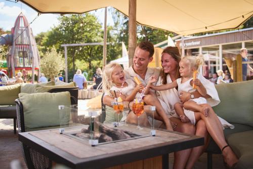 a group of people sitting around a table with drinks at RCN Vakantiepark de Noordster in Dwingeloo