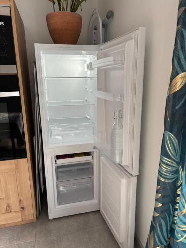 ニヨンにあるGîte cosy avec jardinのキッチンにあるドアが開いたままの空の冷蔵庫