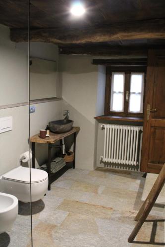 a bathroom with a toilet and a sink at Cascina Manzoni in Bossolasco