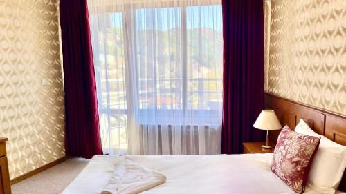 une chambre avec un lit et une grande fenêtre dans l'établissement Хотел Елит Релакс, à Devin